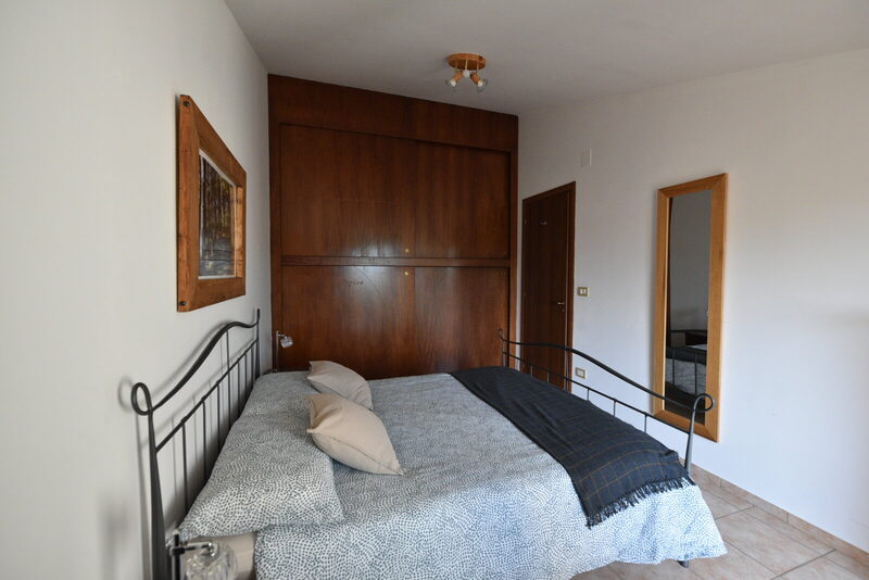 Armadio a tutta parete in legno con decorazioni e scritta Lorica