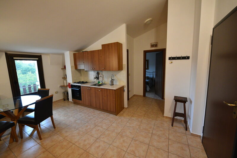 Cucina attrezzata, tavolo da pranzo e accesso al balcone